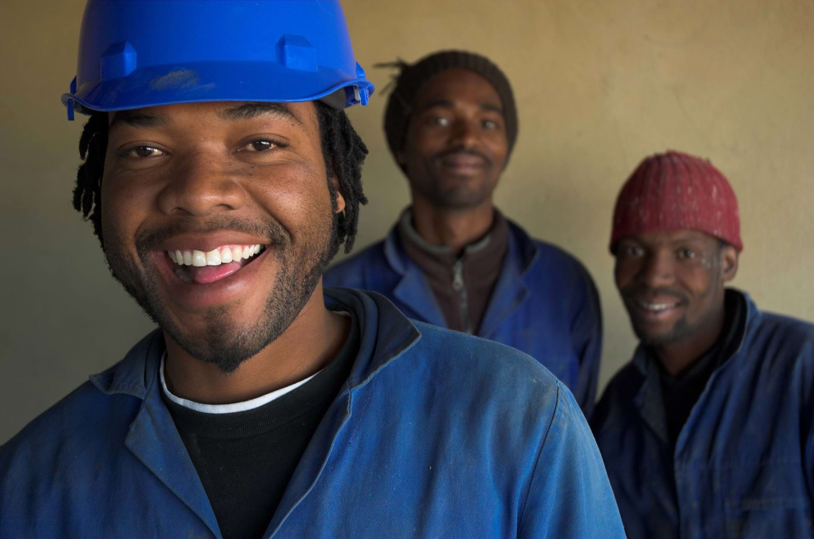 Group of happy men in hard hats